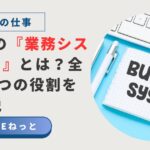 ノートに太字で「Business system」と書かれ、白いキーボードとペンが並ぶデスクトップ写真。社内SEの業務システム担当を紹介するアイキャッチ